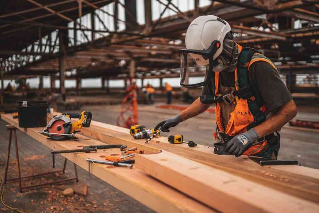 A tradesperson measuring timber on a workshop bench